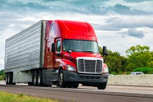 Red semi-truck driving on the highway